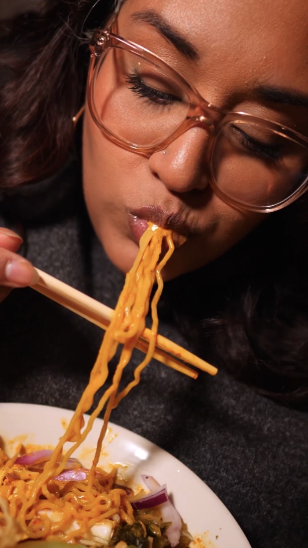 Stephanie lifting noodles with chopsticks